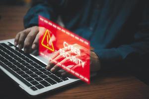 Businessman programmer, developer using laptop computer with triangle caution warning sign. system hacked on computer network cybersecurity vulnerability. photo