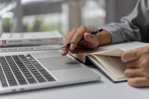 aprender clases en línea usando una computadora portátil y escribiendo un cuaderno en el lugar de trabajo, desarrollo educativo o concepto de mejora del conocimiento. foto