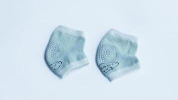 Blue baby knee pad sock isolated on white, knee protection for baby learn to crawl. photo