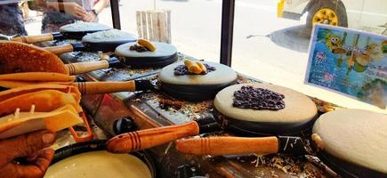 Surakarta, Indonesia, March 12, 2023. Making of kue leker,is a type of Indonesian crepe street food, made with flour, eggs, milk and sugar with various fillings such as banana, chocolate and cheese. photo