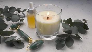 Spa Behandlung Konzept. natürlich Spa Kosmetika Produkte mit Eukalyptus Öl, Massage Jade Rolle, Eukalyptus Blatt. video