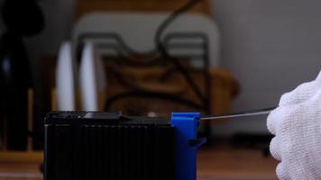 Sharpening a knife on an electric sharpener at home. The man's hand drives the knife blade between the blue sharpeners, dust flies on the machine. 4k, slow motion video