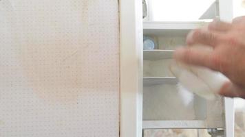 A man pours washing powder into the washing machine compartment, top view. video