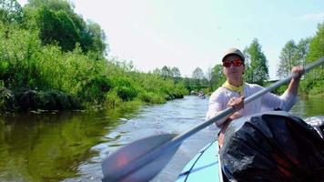 viaje familiar en kayak. padre e hija remando en bote en el río, una caminata acuática, una aventura de verano. turismo ecológico y extremo, estilo de vida activo y saludable video