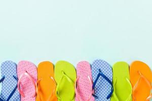 a lot of flip flop colored sandals, summer vacation on colored background, copy space top view photo