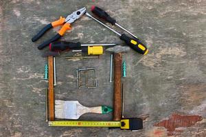 Construction tools in the form of house on wooden background. Top view. Flat lay. photo