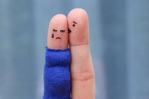 Fingers art of displeased couple. Pregnant cries, man reassures her. He kisses and hugs her. photo