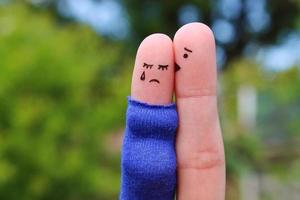 Fingers art of displeased couple. Pregnant cries, man reassures her. He kisses and hugs her. photo