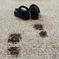sucio piso y para niños zapatos. concepto de niño manchado alfombra. foto