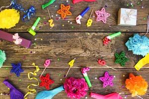 Whistles, balloons gifts, candles, decoration on old wooden background. Concept of children's birthday party. Top view. Flat lay. photo