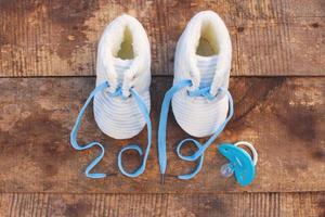 2019 new year written laces of children's shoes and pacifier on old wooden background. Top view. Flat lay. Toned image. photo