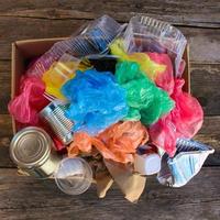 Box with trash on wooden background photo