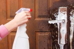 Person washes handle of the front door. photo