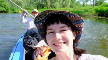 homme et femme couple, bébé est dormant, selfies sont content dans famille kayak voyage aviron bateau sur le rivière, l'eau randonnée, une été aventure. respectueux de la nature et extrême tourisme, actif et en bonne santé mode de vie video