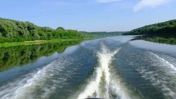 Waves on the river in summer from the motor of the boat behind. Water travel, river boat tour, domestic tourism video