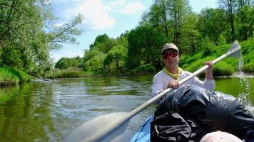 familjekajaktur. far och dotter roddbåt på floden, en vattenvandring, ett sommaräventyr. miljövänlig och extrem turism, aktiv och hälsosam livsstil video