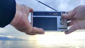 suchen zum Radio Kanäle Tuning mit Tasche Radio auf ein wolkig Tag beim das Strand video