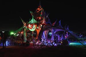 People walking towards sunset at a festival in the desert at the Burning Man Festival. photo