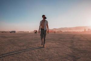 personas caminando hacia puesta de sol a un festival en el Desierto a el ardiente hombre festival. foto