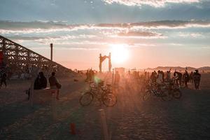 People walking towards sunset at a festival in the desert at the Burning Man Festival. photo