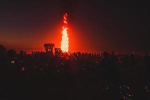 personas caminando hacia puesta de sol a un festival en el Desierto a el ardiente hombre festival. foto