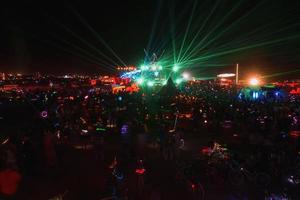 personas caminando hacia puesta de sol a un festival en el Desierto a el ardiente hombre festival. foto