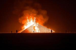 personas caminando hacia puesta de sol a un festival en el Desierto a el ardiente hombre festival. foto