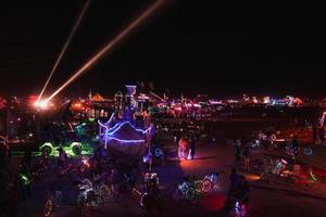 personas caminando hacia puesta de sol a un festival en el Desierto a el ardiente hombre festival. foto