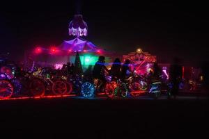 People walking towards sunset at a festival in the desert at the Burning Man Festival. photo