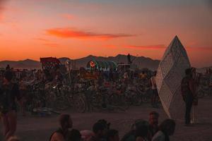 People walking towards sunset at a festival in the desert at the Burning Man Festival. photo