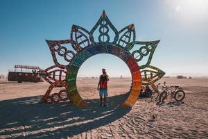 personas caminando hacia puesta de sol a un festival en el Desierto a el ardiente hombre festival. foto