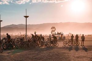 People walking towards sunset at a festival in the desert at the Burning Man Festival. photo