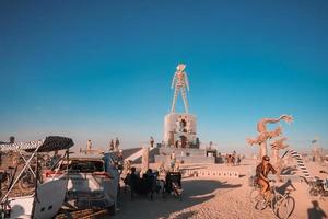 People walking towards sunset at a festival in the desert at the Burning Man Festival. photo