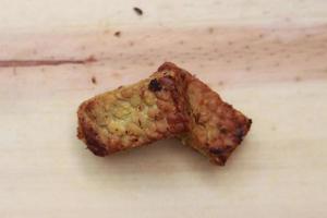 a close up of fried tempeh on a wooden cutting board photo