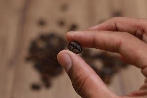 Detailed photo of coffee beans before being processed into a drink isolated on wood. Concept photo of the basic ingredients of coffee drinks.