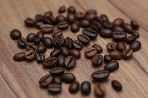 Detailed photo of coffee beans before being processed into a drink isolated on wood. Concept photo of the basic ingredients of coffee drinks.