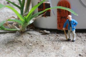 miniatura figura de un abuelo quien es esperando en frente de el casa. foto