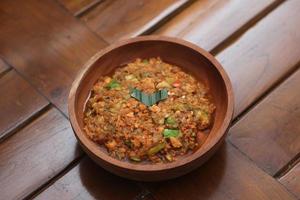 a close up Rujak Bebek or smashed fruit which is made from raw fruit crushed in a mortar and pestle and added with shrimp paste, chili and brown sugar. Indonesian traditional food photo concept.