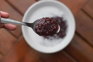 a bowl of black sticky rice porridge with coconut milk photo