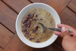 a close up of a bowl of green bean porridge and black sticky rice doused in coconut milk photo