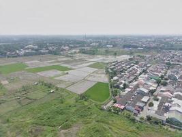 aerial view of various rice fields pattern side by side with local residents houses. photo