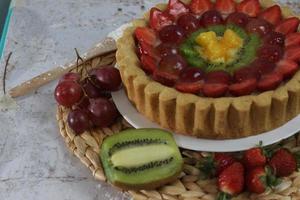 big fruit pie with toppings of strawberries, grapes, kiwi and pineapple. savory, sweet and fresh. Food concept photo. photo