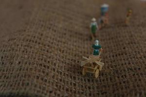 miniature figures of farmers working on gunny sacks. concept of agriculture photo. photo