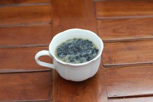 a close up of a glass of a traditional Indonesian drink called Dawet Ireng or black dawet. Indonesian traditional food photo concept.