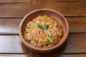a close up Rujak Bebek or smashed fruit which is made from raw fruit crushed in a mortar and pestle and added with shrimp paste, chili and brown sugar. Indonesian traditional food photo concept.
