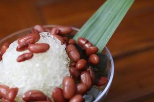 Es Kacang Merah or a cold drink made from red beans boiled with brown sugar served with coconut milk, shaved ice and covered with sweetened condensed milk chocolate and syrup. photo