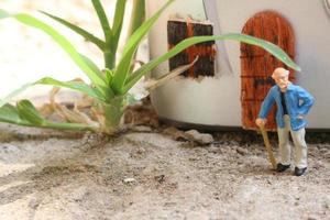 miniature figure of a grandfather who is waiting in front of the house. photo