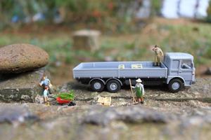 photo of miniature figure with the concept of workers ready to lift good onto trucks