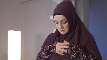 moslim vrouw in hijab is bidden. religieus moslim paar bidden in hun huis, aanbidden Allah. video