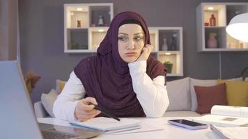 Business woman in hijab thoughtful and upset about business. A veiled Muslim woman working from home does not go well and thinks. video